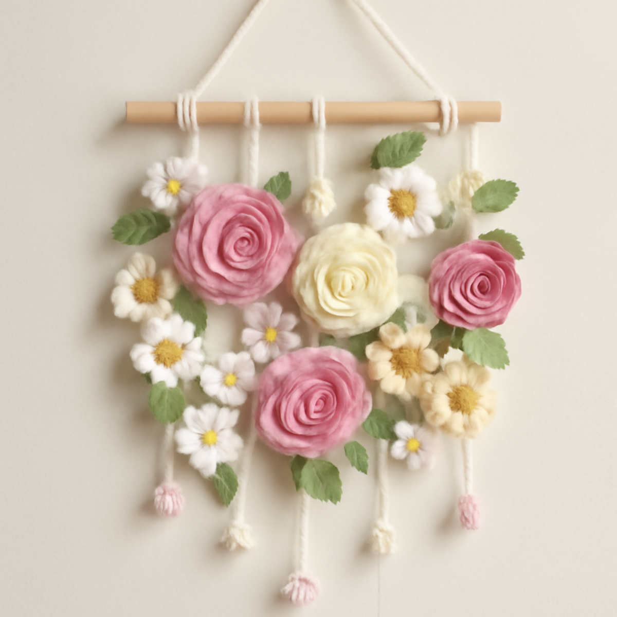 A Charming Crochet Flower Wall Hanging featuring pastel flowers in pink, white, yellow, and green, cascading from a wooden dowel.