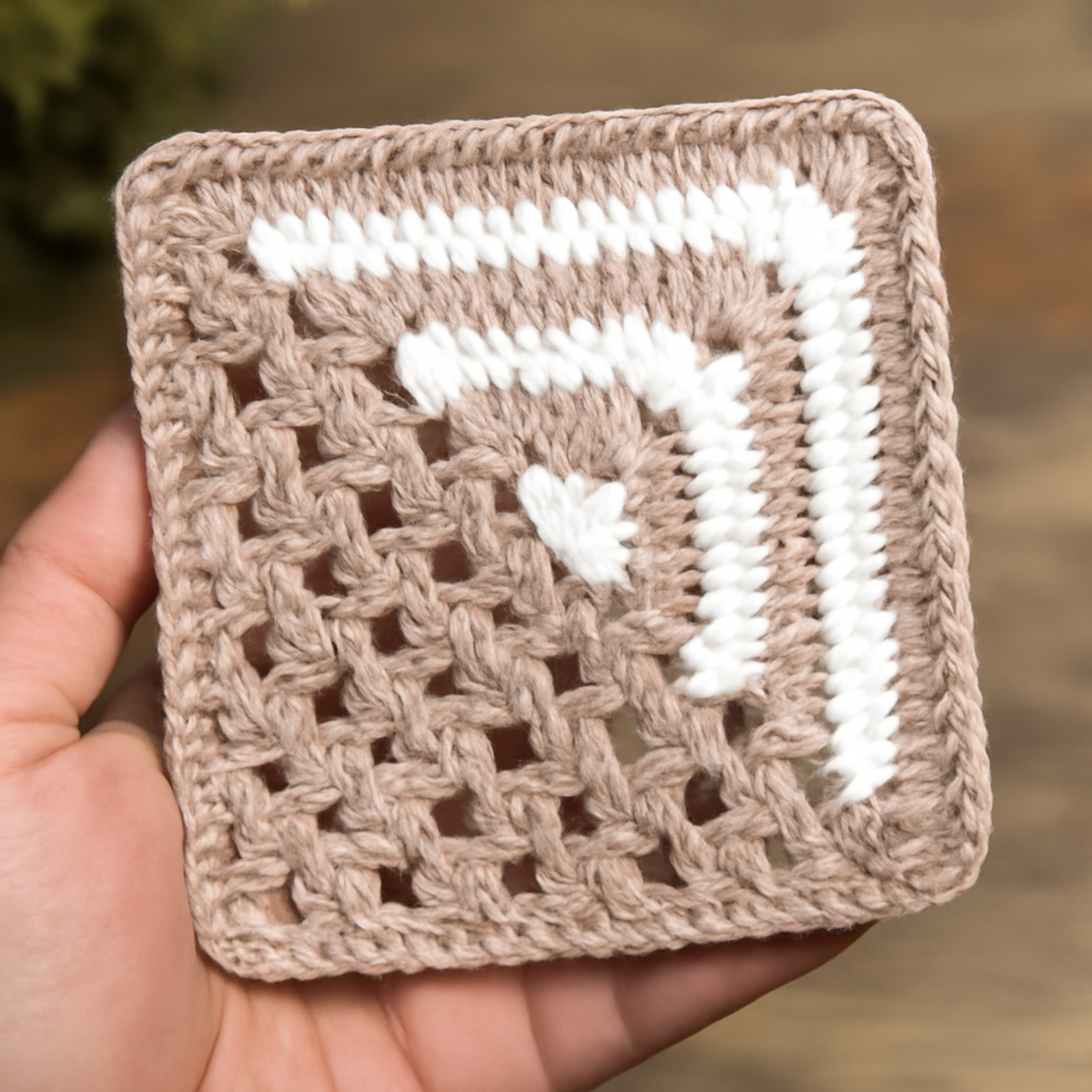 A light tan and white Classic Granny Square Pattern displayed, featuring double crochet stitches, chain spaces, and a zigzag design, measuring approximately 6 to 8 inches per side.